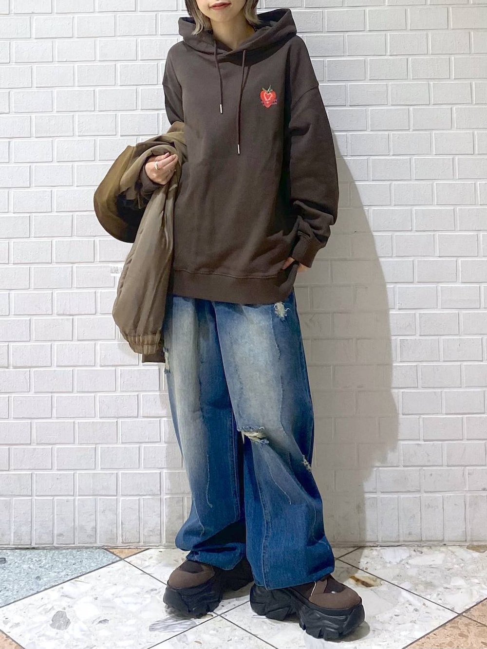 ブラウン系のブーツ、ブルー系のデニムパンツ、ブラウン系のパーカーを着用したレディースの秋コーディネートの3枚目の写真