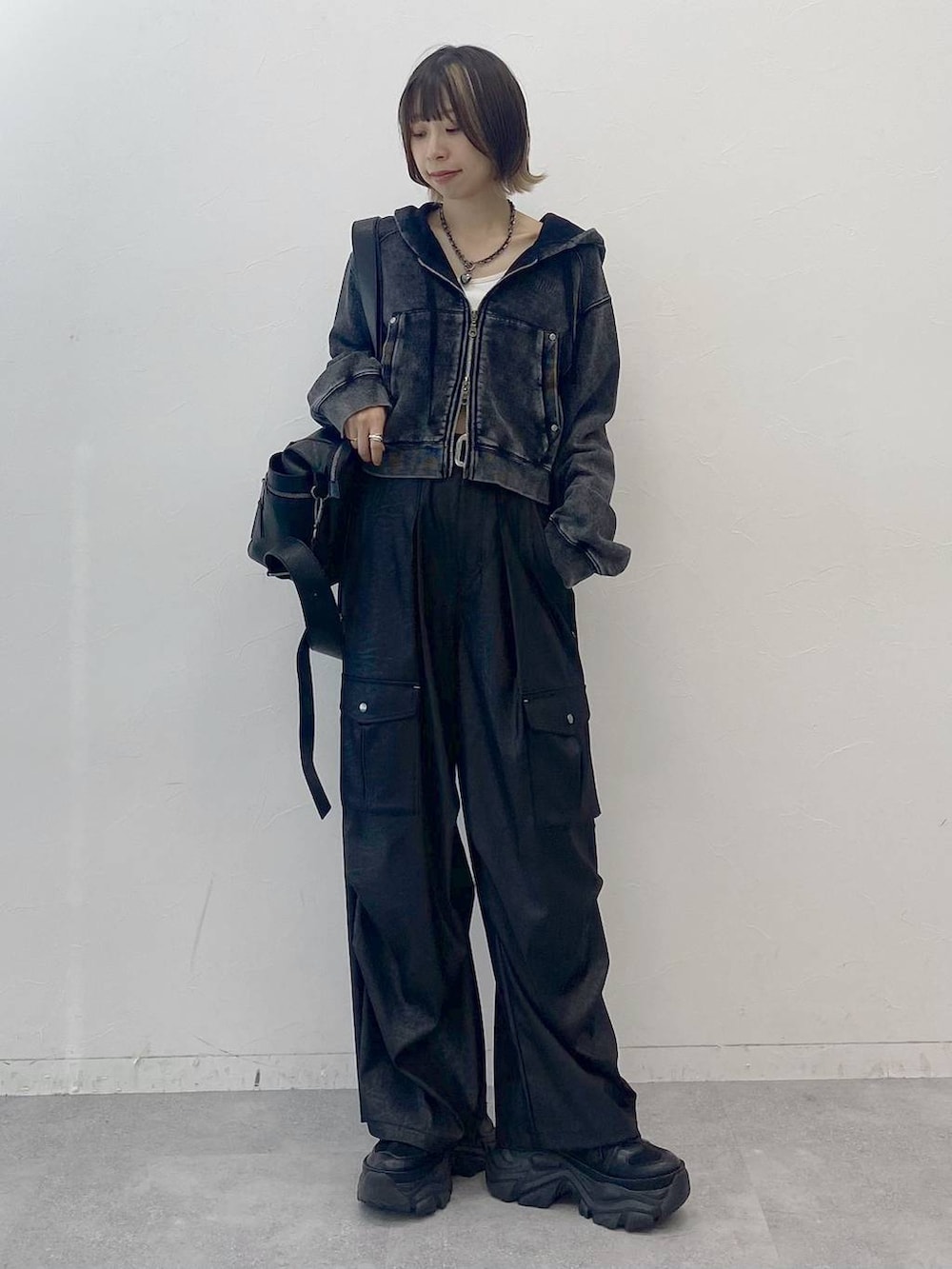 ブラック系のスニーカー、ホワイト系のキャミソール、ブラック系のカーゴパンツを着用したレディースの夏コーディネートの7枚目の写真