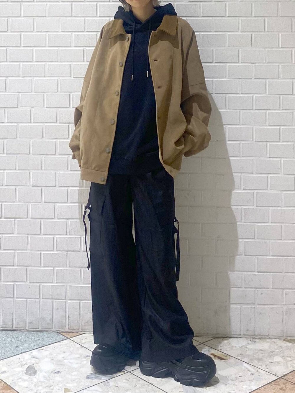 ブラック系のブーツ、ブラック系のパーカー、ベージュ系のブルゾンを着用したレディースの秋コーディネートの2枚目の写真