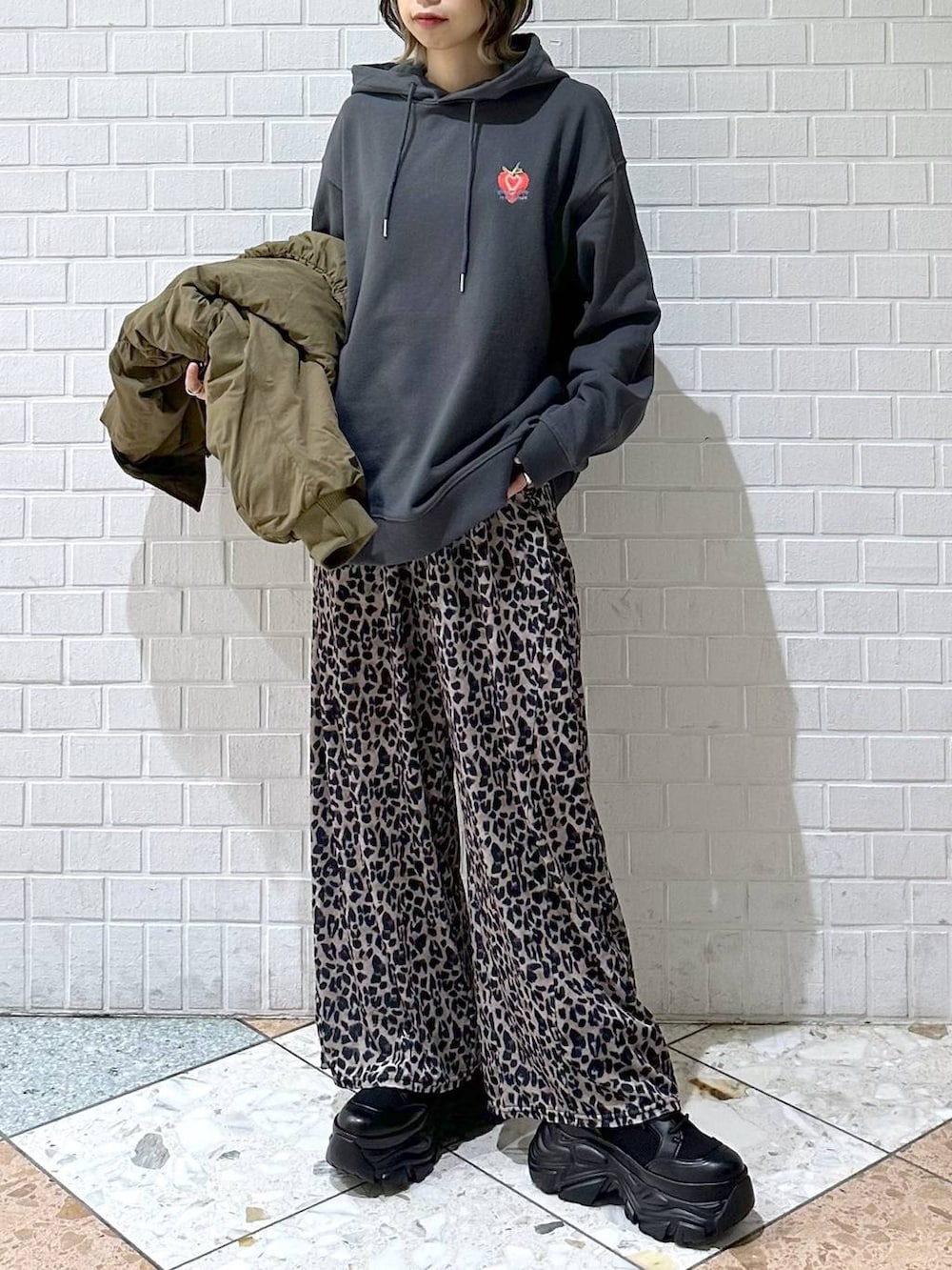 ブラック系のブーツ、グレー系のパーカー、ベージュ系のその他パンツを着用したレディースの冬コーディネートの2枚目の写真