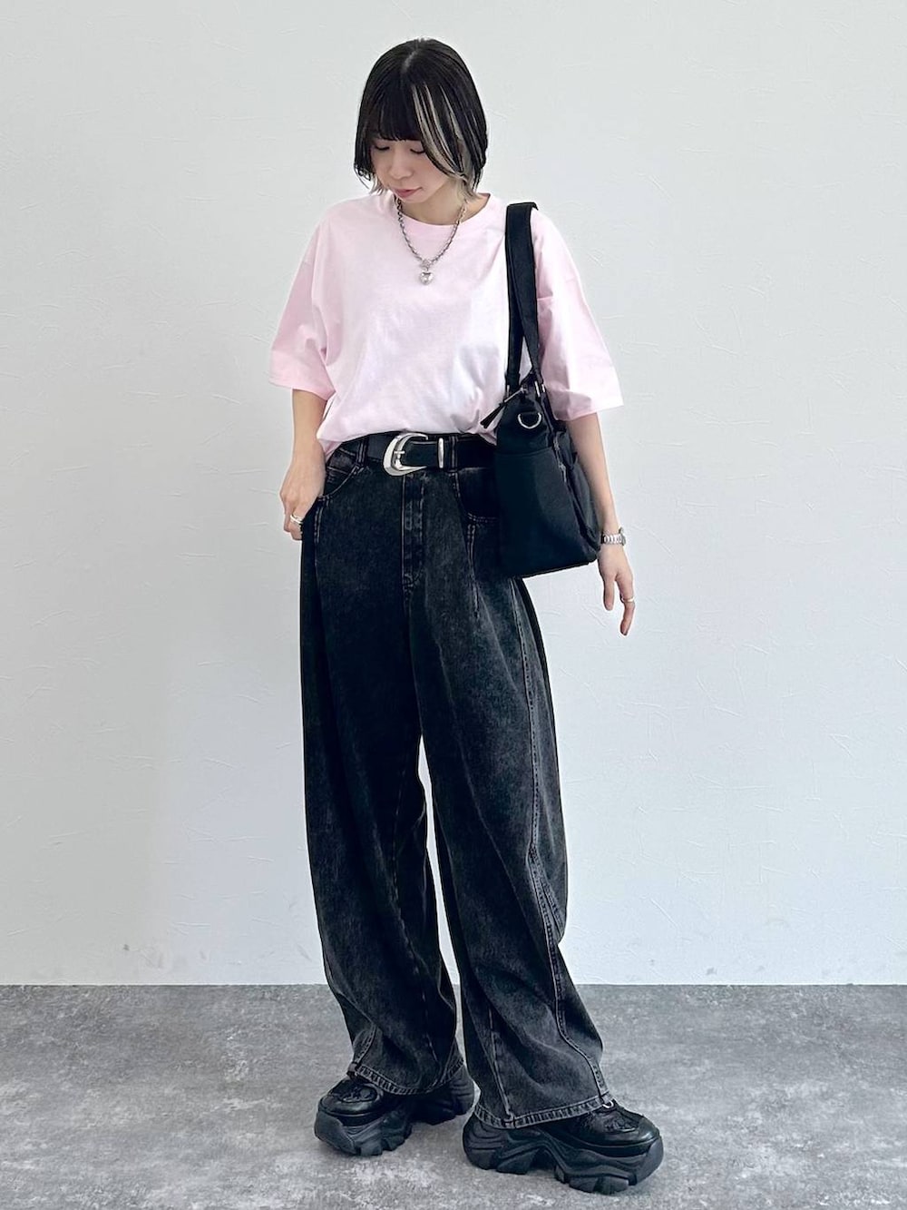 ブラック系のスニーカー、ブラック系のボストンバッグ、ブラック系のデニムパンツを着用したレディースの春コーディネートの3枚目の写真