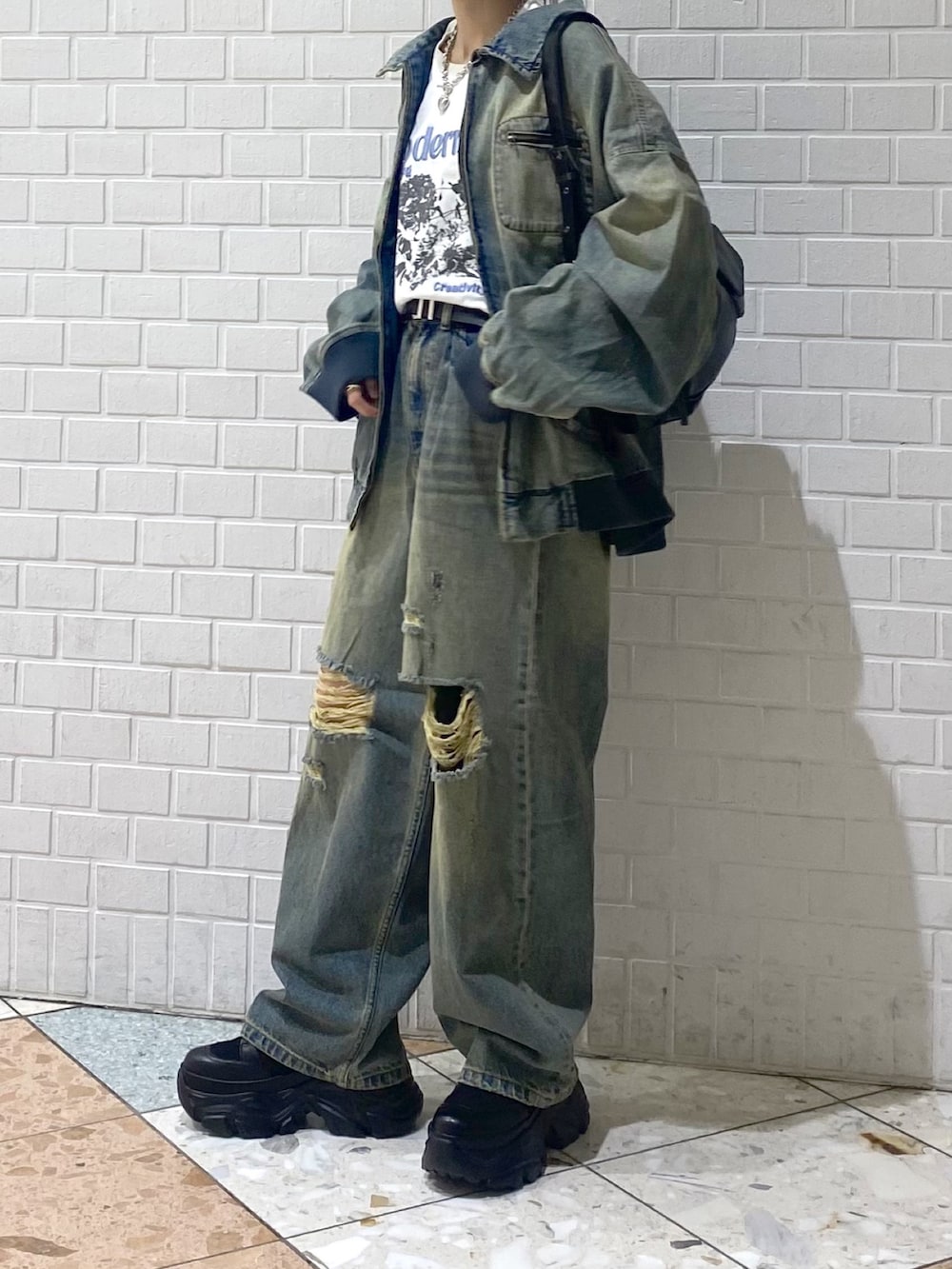 ブラック系のブーツ、ブルー系のデニムパンツ、ホワイト系のTシャツ/カットソーを着用したレディースの秋コーディネートの7枚目の写真