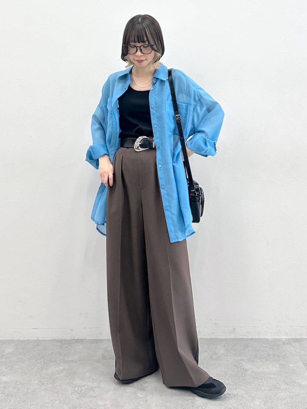 ブラック系のキャミソール、ブラック系のスニーカー、ブラック系のショルダーバッグを着用したレディースの春コーディネートの4枚目の写真