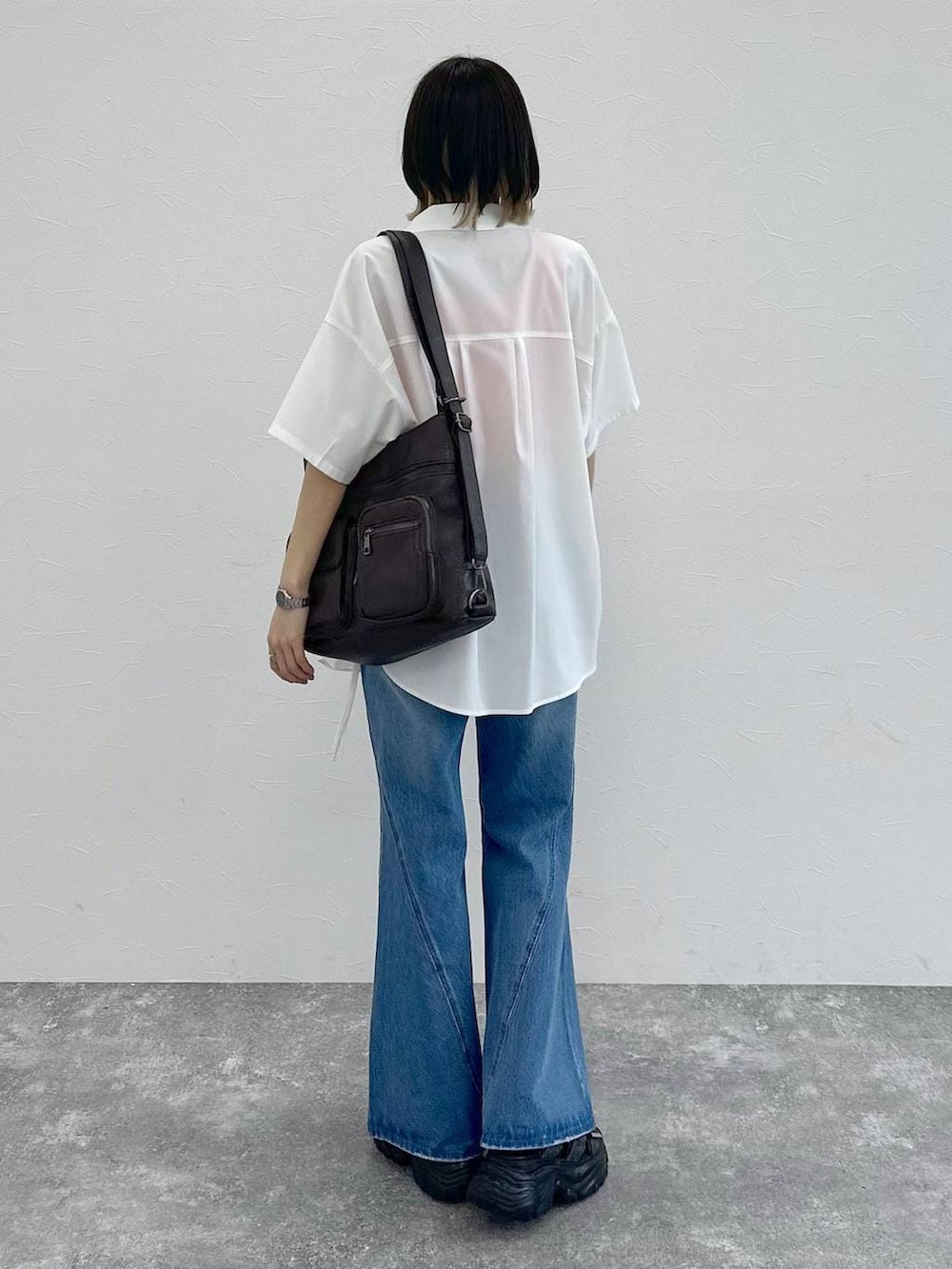 ブルー系のデニムパンツ、ブラック系のショルダーバッグ、グレー系のサンダルを着用したレディースの春コーディネートの7枚目の写真