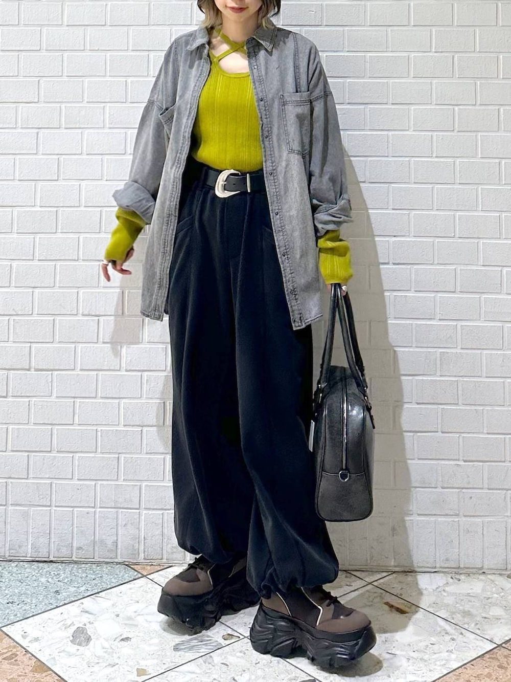 ブラウン系のブーツ、ブラック系のボストンバッグ、ブラック系のシャツ/ブラウスを着用したレディースの冬コーディネートの3枚目の写真