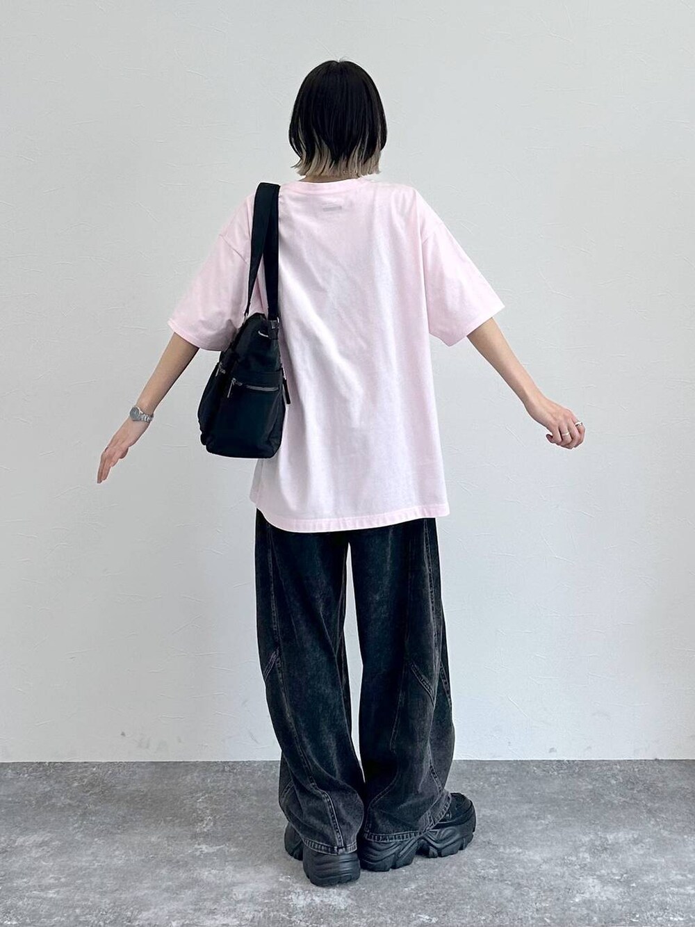 ブラック系のスニーカー、ブラック系のボストンバッグ、ブラック系のデニムパンツを着用したレディースの春コーディネートの7枚目の写真