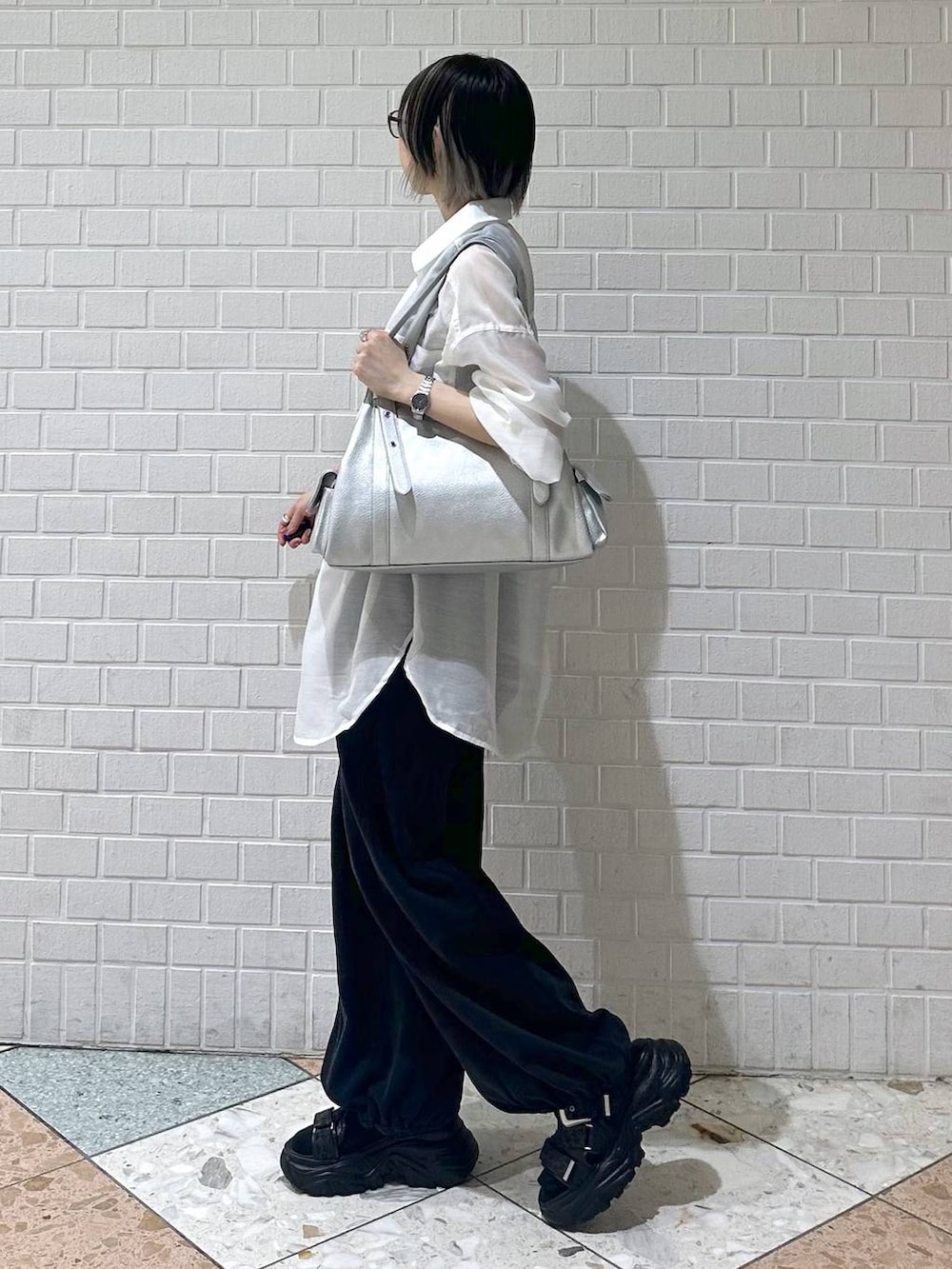 ブラック系のスウェットパンツ、ブラック系のサンダル、ホワイト系のシャツ/ブラウスを着用したレディースの春コーディネートの4枚目の写真