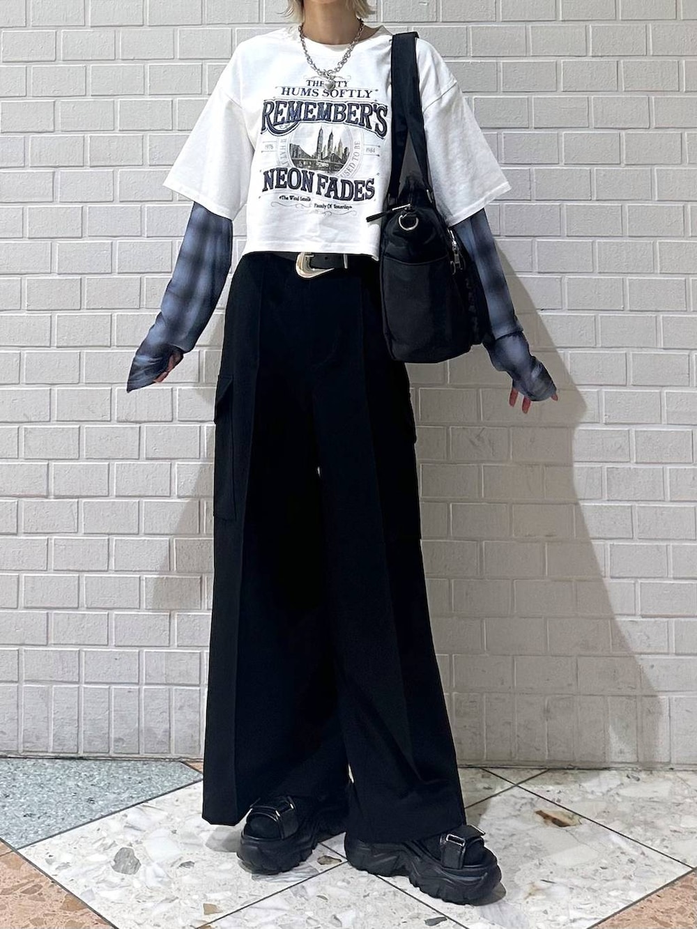 ブラック系のボストンバッグ、ブラック系のサンダル、ホワイト系のTシャツ/カットソーを着用したレディースの春コーディネートの3枚目の写真