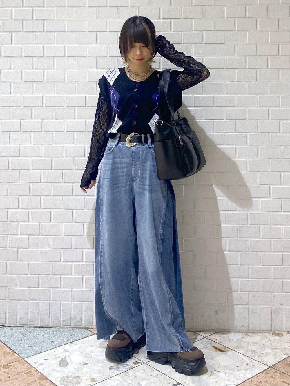 ブラウン系のブーツ、ブルー系のデニムパンツ、ブラック系のボストンバッグを着用したレディースの夏コーディネートの8枚目の写真