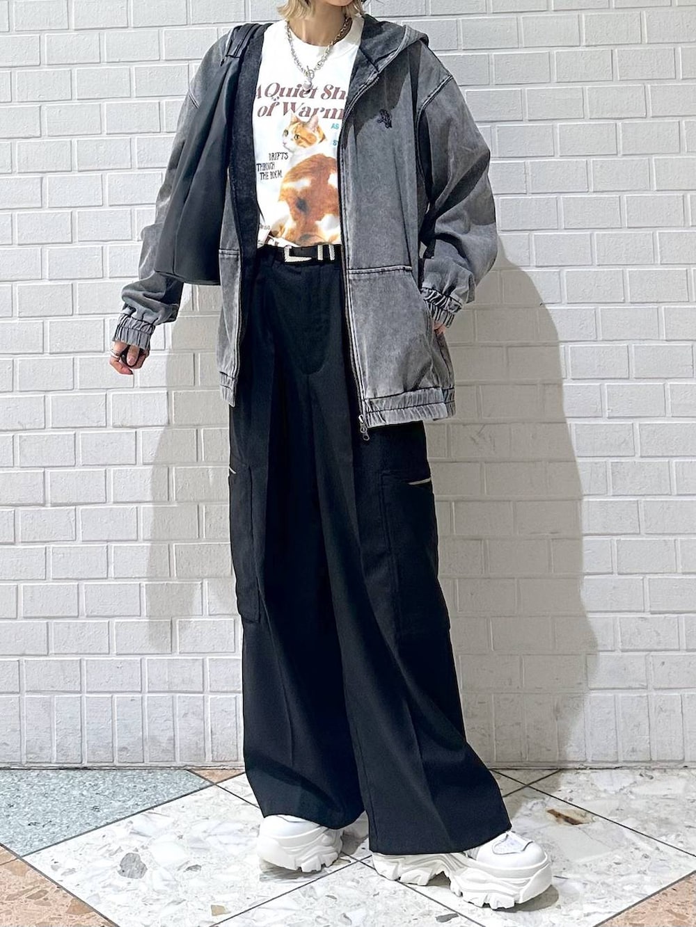 ホワイト系のスニーカー、ブラック系のスラックス、ブラック系のパーカーを着用したレディースの春コーディネートの9枚目の写真