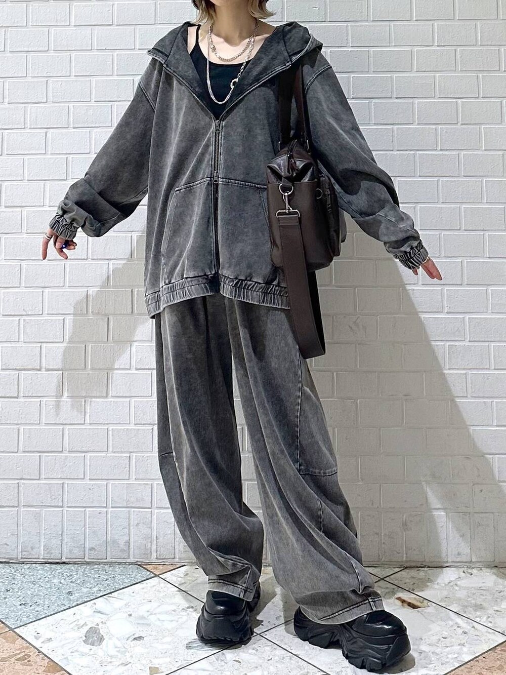 ブラック系のブーツ、ブラック系のキャミソール、ブラウン系のボストンバッグを着用したレディースの冬コーディネートの2枚目の写真