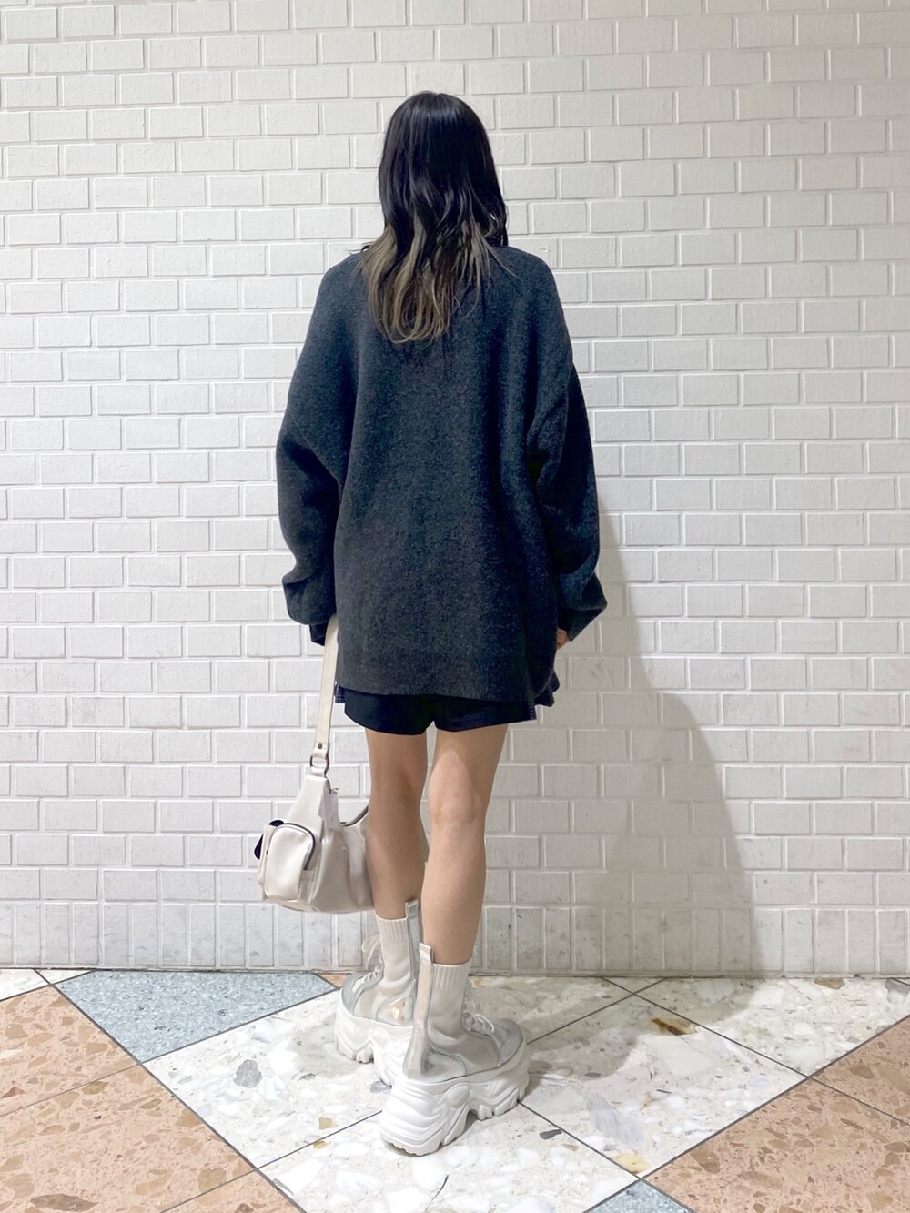 ホワイト系のブーツ、ホワイト系のショルダーバッグ、ブラック系のその他パンツを着用したレディースの秋コーディネートの3枚目の写真