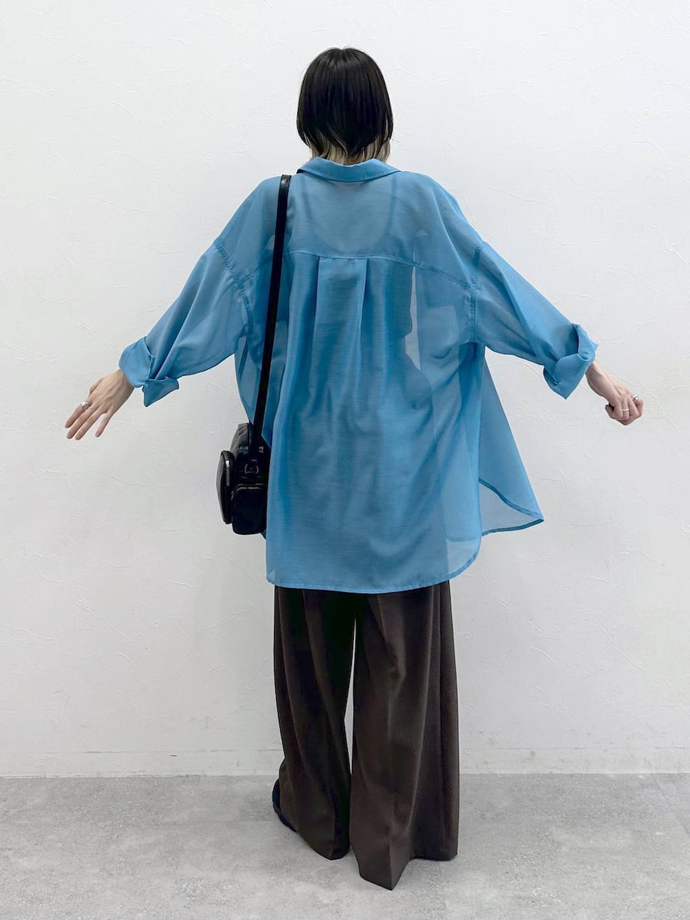 ブラック系のキャミソール、ブラック系のスニーカー、ブラック系のショルダーバッグを着用したレディースの春コーディネートの7枚目の写真