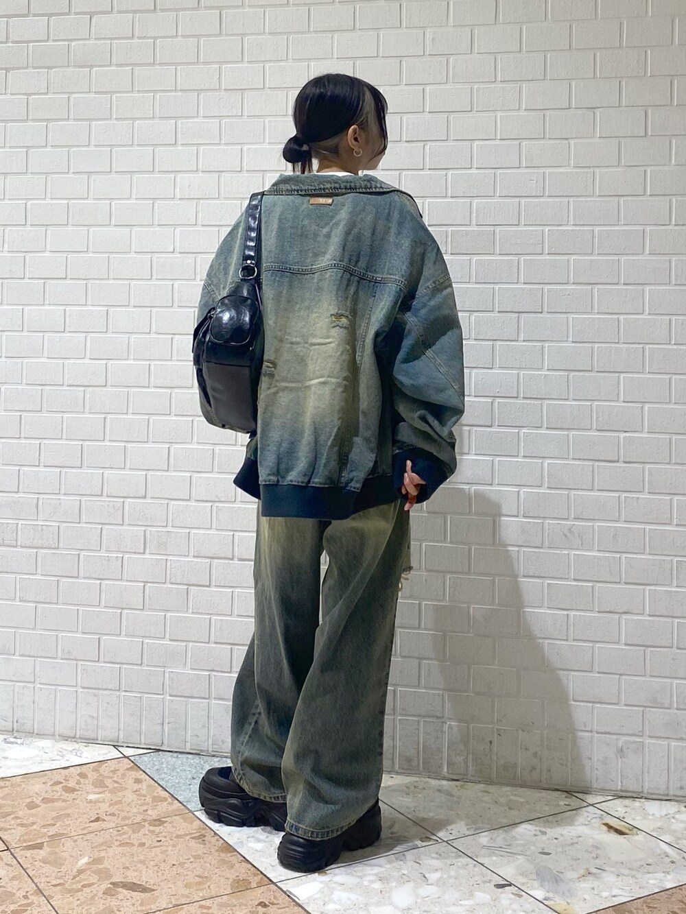 ブラック系のブーツ、ブルー系のデニムパンツ、ホワイト系のTシャツ/カットソーを着用したレディースの秋コーディネートの4枚目の写真