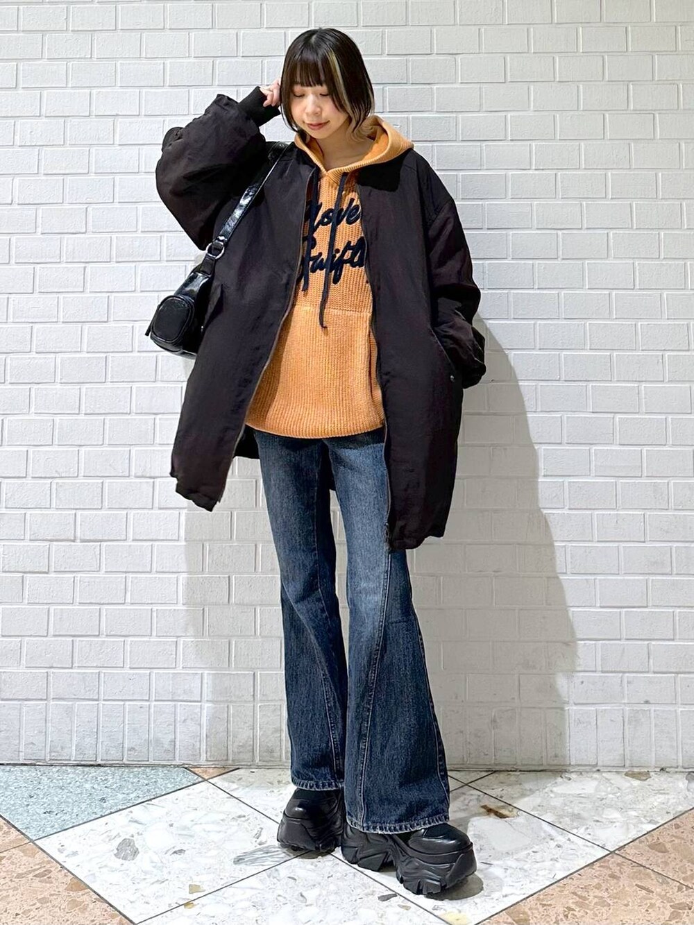 ブラック系のブーツ、ブルー系のデニムパンツ、ブラウン系のブルゾンを着用したレディースの秋コーディネートの8枚目の写真