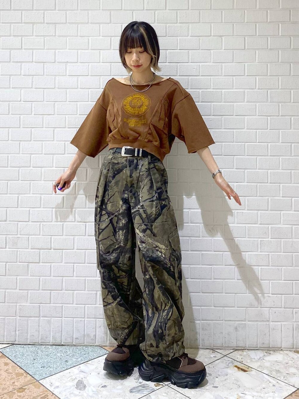 ブラウン系のブーツ、グリーン系のカーゴパンツ、ブラウン系のTシャツ/カットソーを着用したレディースの夏コーディネートの3枚目の写真