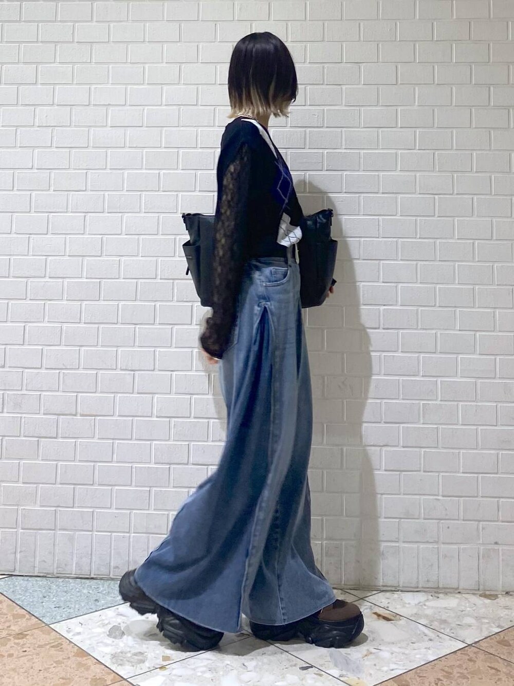 ブラウン系のブーツ、ブルー系のデニムパンツ、ブラック系のボストンバッグを着用したレディースの夏コーディネートの7枚目の写真