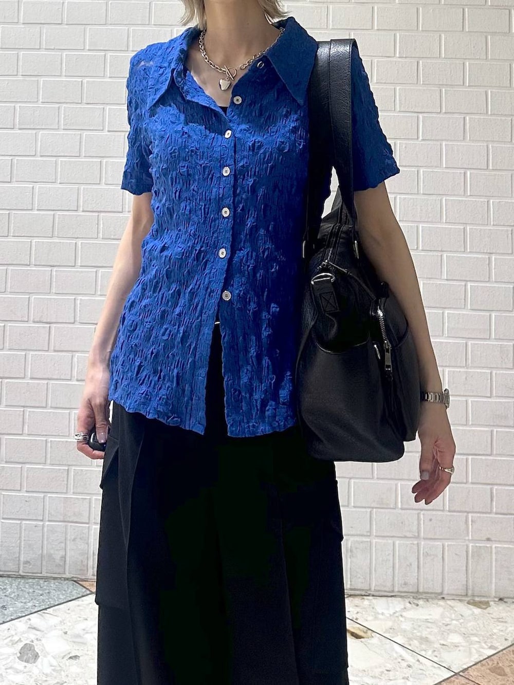 ブラック系のボストンバッグ、グレー系のサンダル、ブラック系のスラックスを着用したレディースの夏コーディネートの8枚目の写真