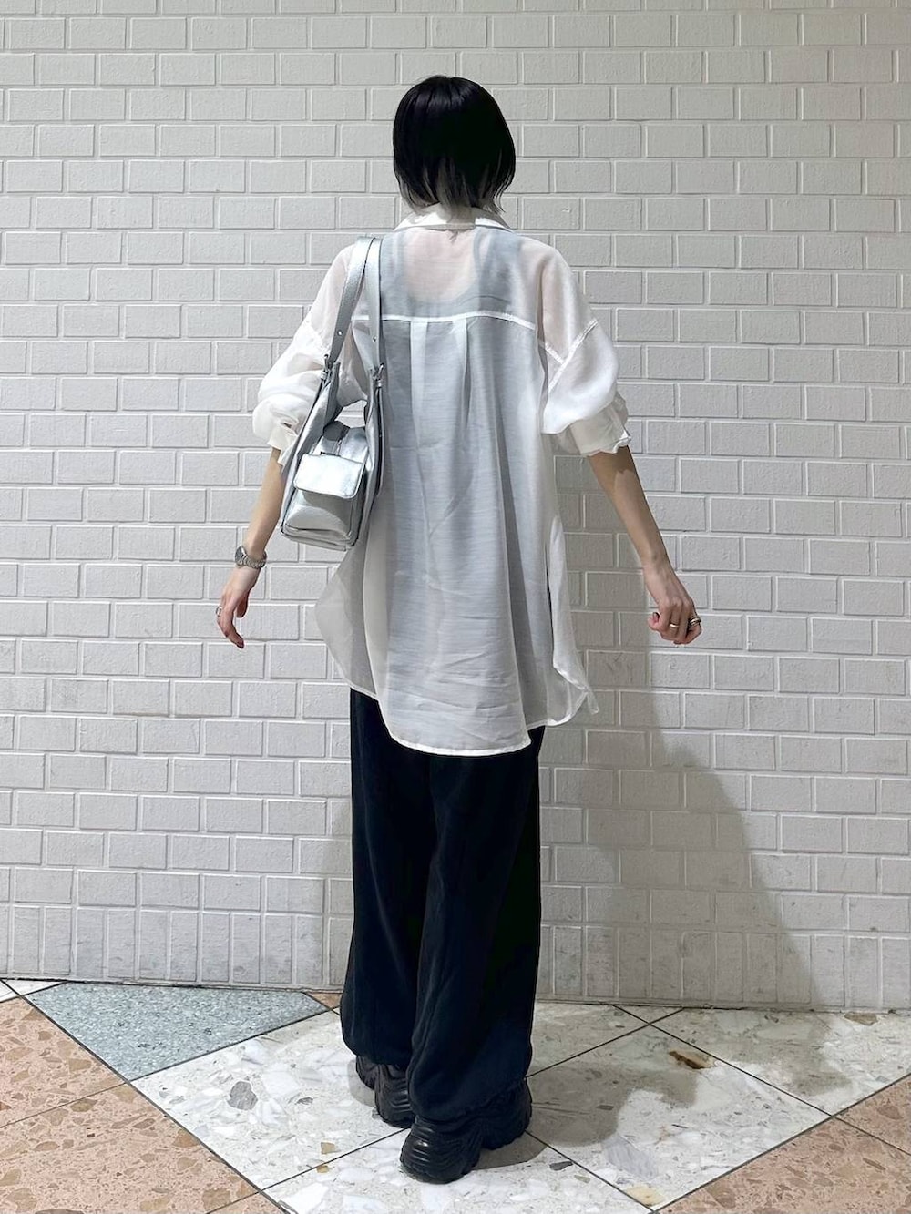 ブラック系のスウェットパンツ、ブラック系のサンダル、ホワイト系のシャツ/ブラウスを着用したレディースの春コーディネートの5枚目の写真
