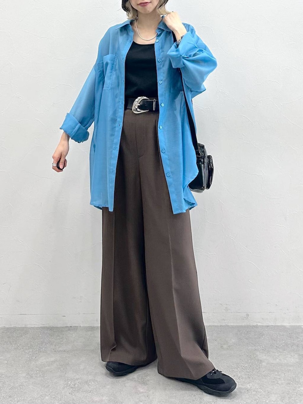 ブラック系のキャミソール、ブラック系のスニーカー、ブラック系のショルダーバッグを着用したレディースの春コーディネートの2枚目の写真