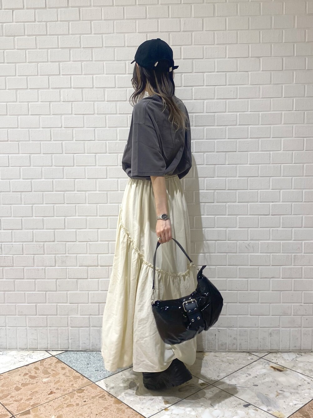 ブラック系のショルダーバッグ、ブラック系のスニーカー、ホワイト系のスカートを着用したレディースの夏コーディネートの3枚目の写真