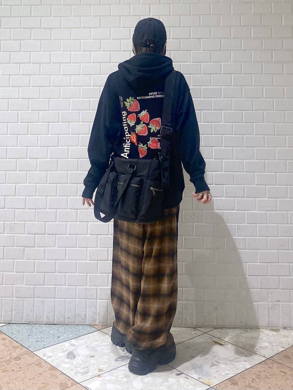 ブラウン系のブーツ、ブラック系のボストンバッグ、ブラック系のパーカーを着用したレディースの秋コーディネートの6枚目の写真