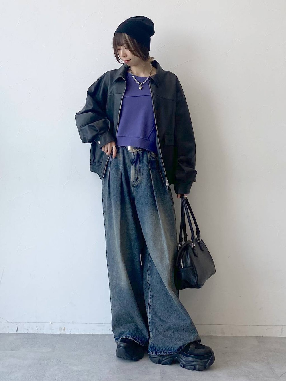 ブラック系のスニーカー、ブルー系のデニムパンツ、ブラック系のブルゾンを着用したレディースの夏コーディネートの8枚目の写真