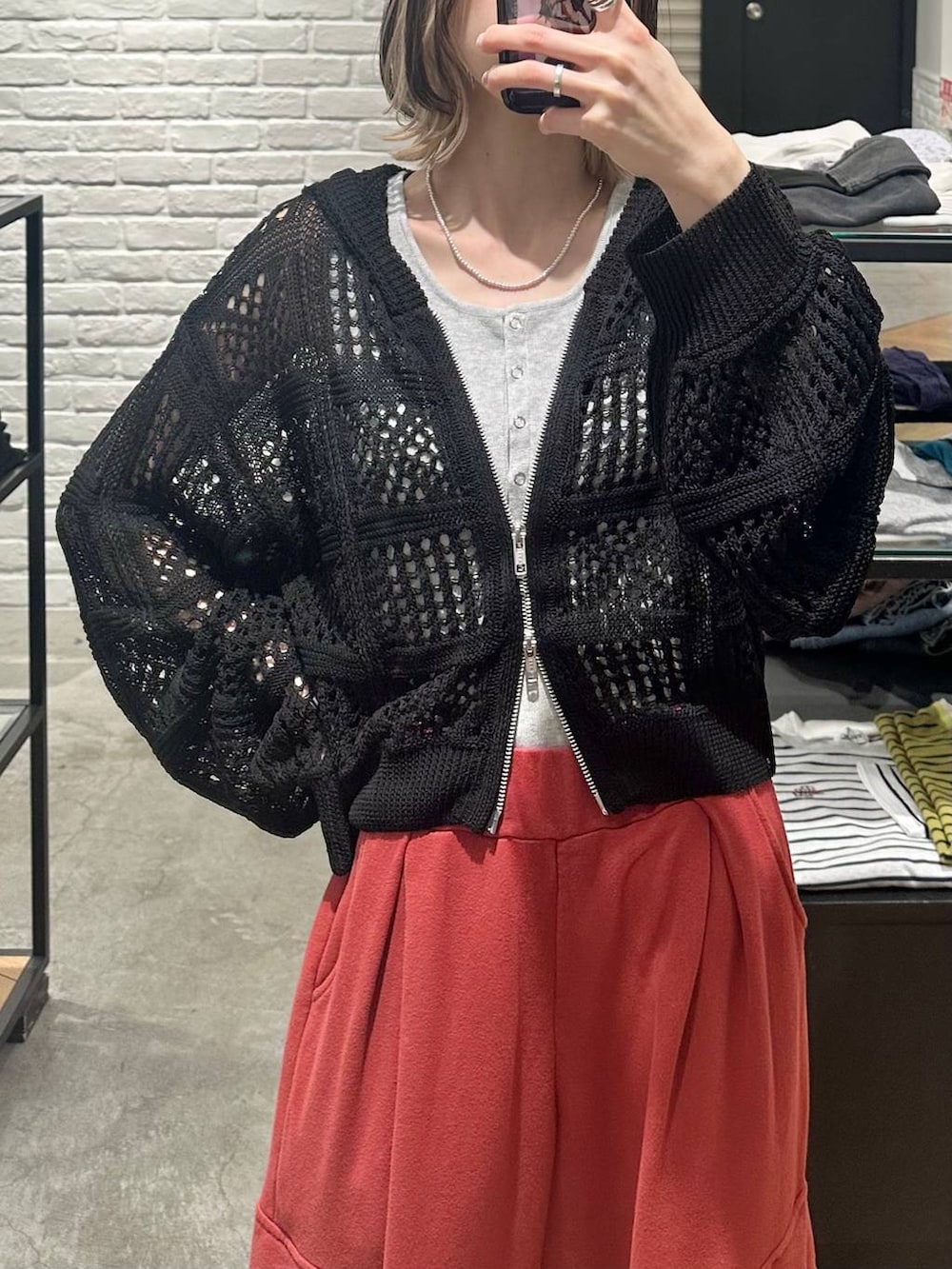 ブラック系のパーカー、グレー系のタンクトップ、レッド系のその他パンツを着用したレディースの春コーディネートの3枚目の写真