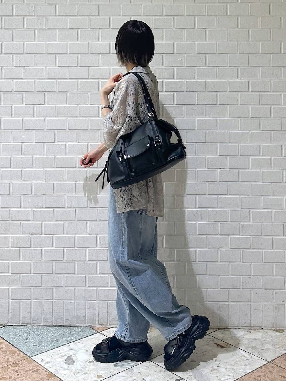 ブラック系のキャミソール、ベージュ系のシャツ/ブラウス、ブルー系のデニムパンツを着用したレディースの春コーディネートの5枚目の写真