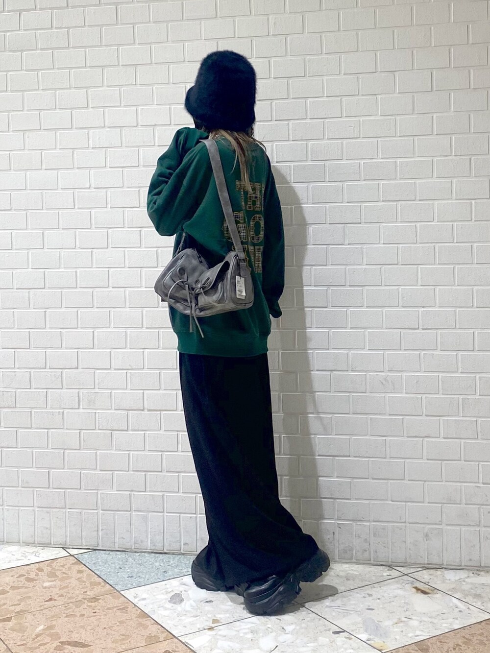 ブラック系のブーツ、ブラック系のスラックス、グレー系のショルダーバッグを着用したレディースの秋コーディネートの5枚目の写真