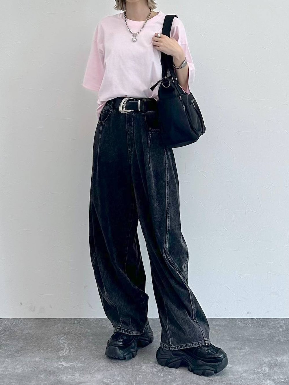 ブラック系のスニーカー、ブラック系のボストンバッグ、ブラック系のデニムパンツを着用したレディースの春コーディネートの9枚目の写真