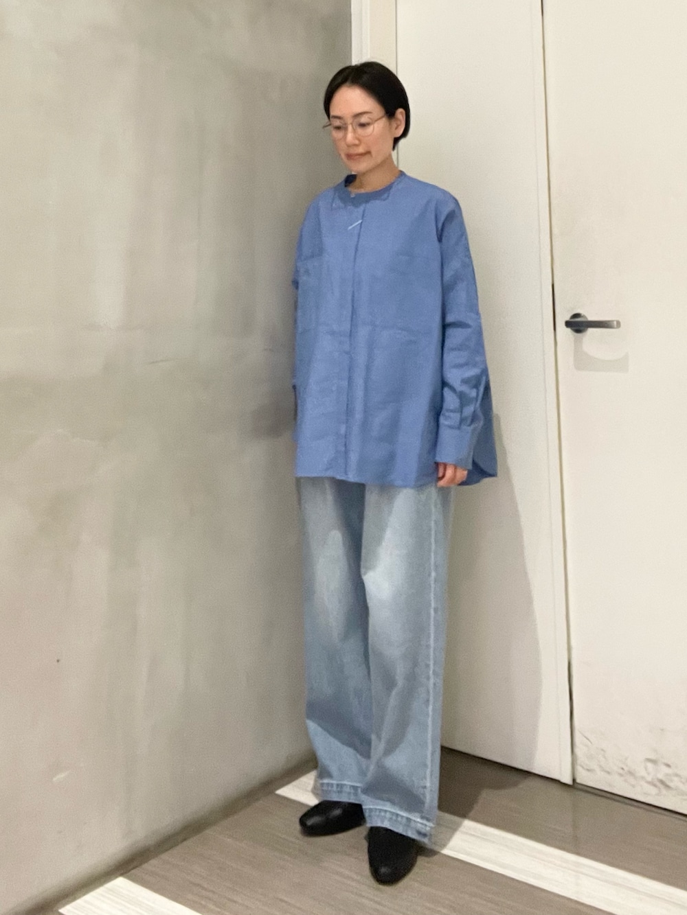 ブルー系のシャツ/ブラウス、ブルー系のデニムパンツ、ホワイト系のベストを着用したレディースの冬コーディネートの5枚目の写真