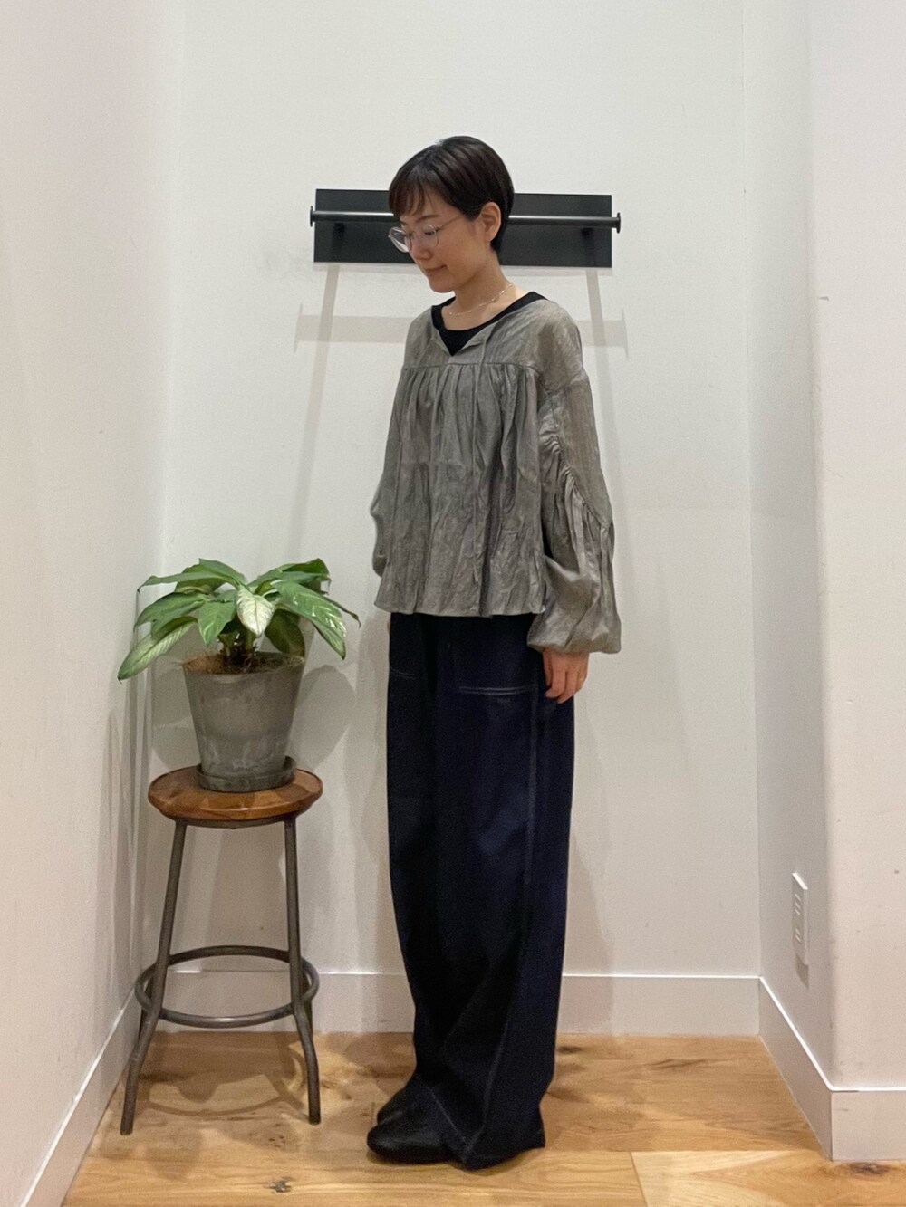 ブラック系のスニーカー、ブラック系のタンクトップ、ブルー系のデニムパンツを着用したレディースの春コーディネートの2枚目の写真