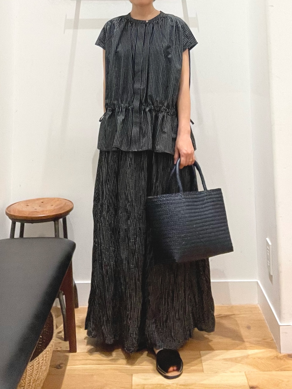 ブラック系のシャツ/ブラウス、ブルー系のトートバッグ、ブラック系のサンダルを着用したレディースの夏コーディネートの2枚目の写真