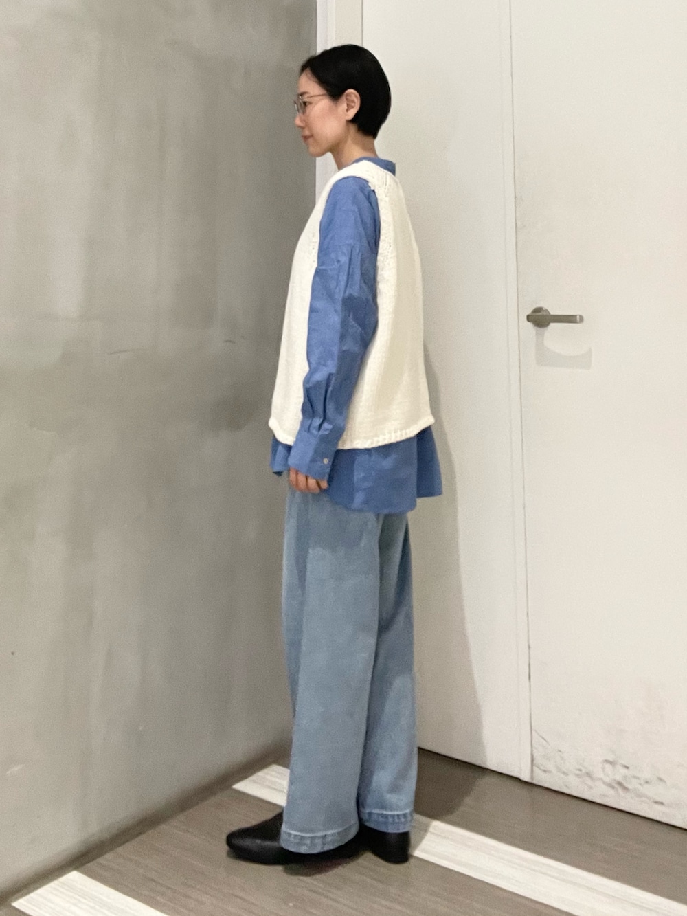 ブルー系のシャツ/ブラウス、ブルー系のデニムパンツ、ホワイト系のベストを着用したレディースの冬コーディネートの2枚目の写真