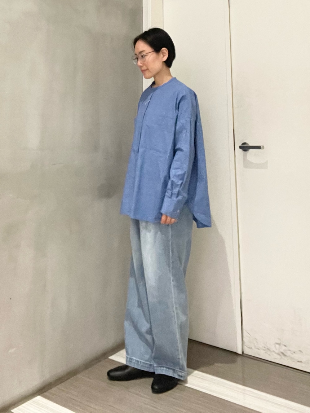 ブルー系のシャツ/ブラウス、ブルー系のデニムパンツ、ホワイト系のベストを着用したレディースの冬コーディネートの6枚目の写真