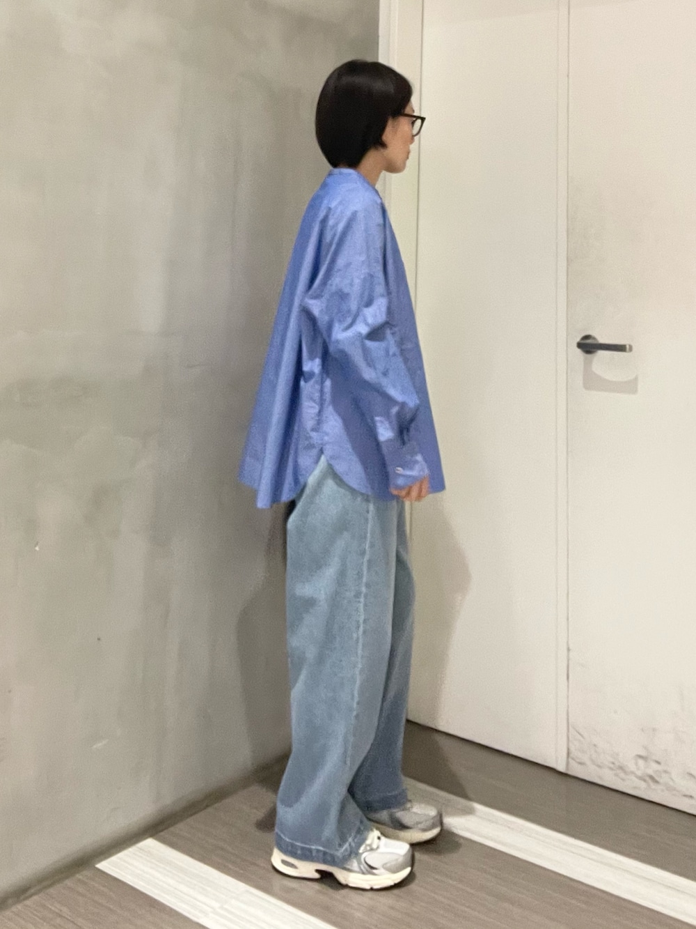 ブルー系のデニムパンツ、ブルー系のシャツ/ブラウス、ブラック系のハンドバッグを着用したレディースの冬コーディネートの4枚目の写真