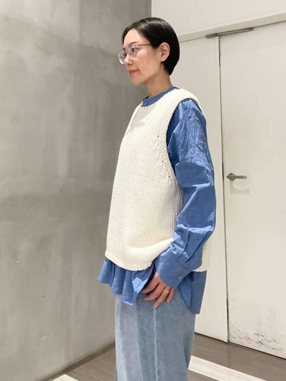 ブルー系のシャツ/ブラウス、ブルー系のデニムパンツ、ホワイト系のベストを着用したレディースの冬コーディネートの3枚目の写真