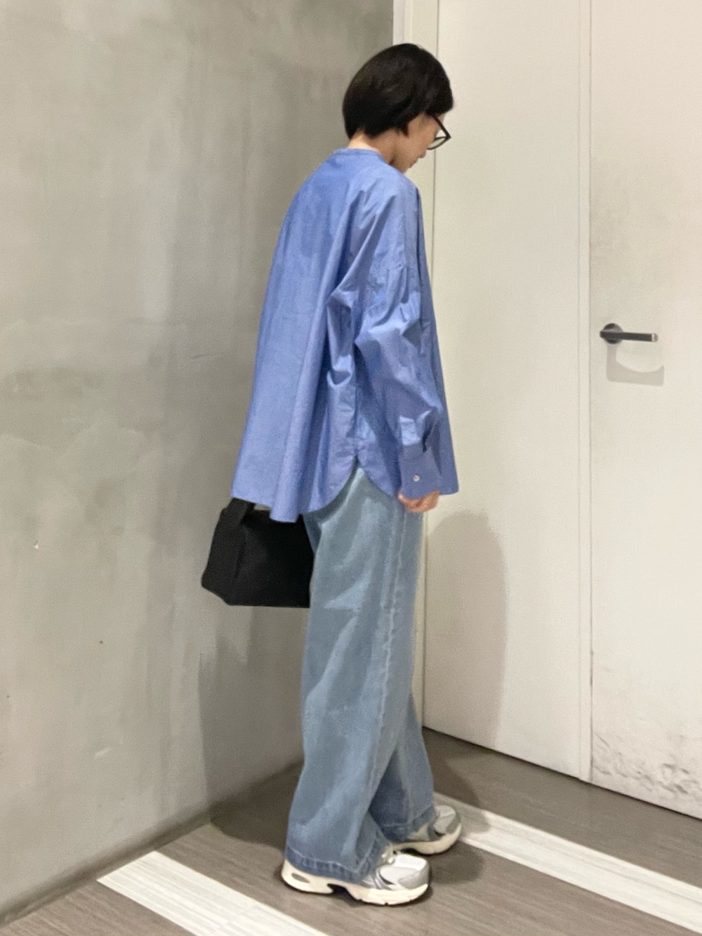 ブルー系のデニムパンツ、ブルー系のシャツ/ブラウス、ブラック系のハンドバッグを着用したレディースの冬コーディネートの3枚目の写真