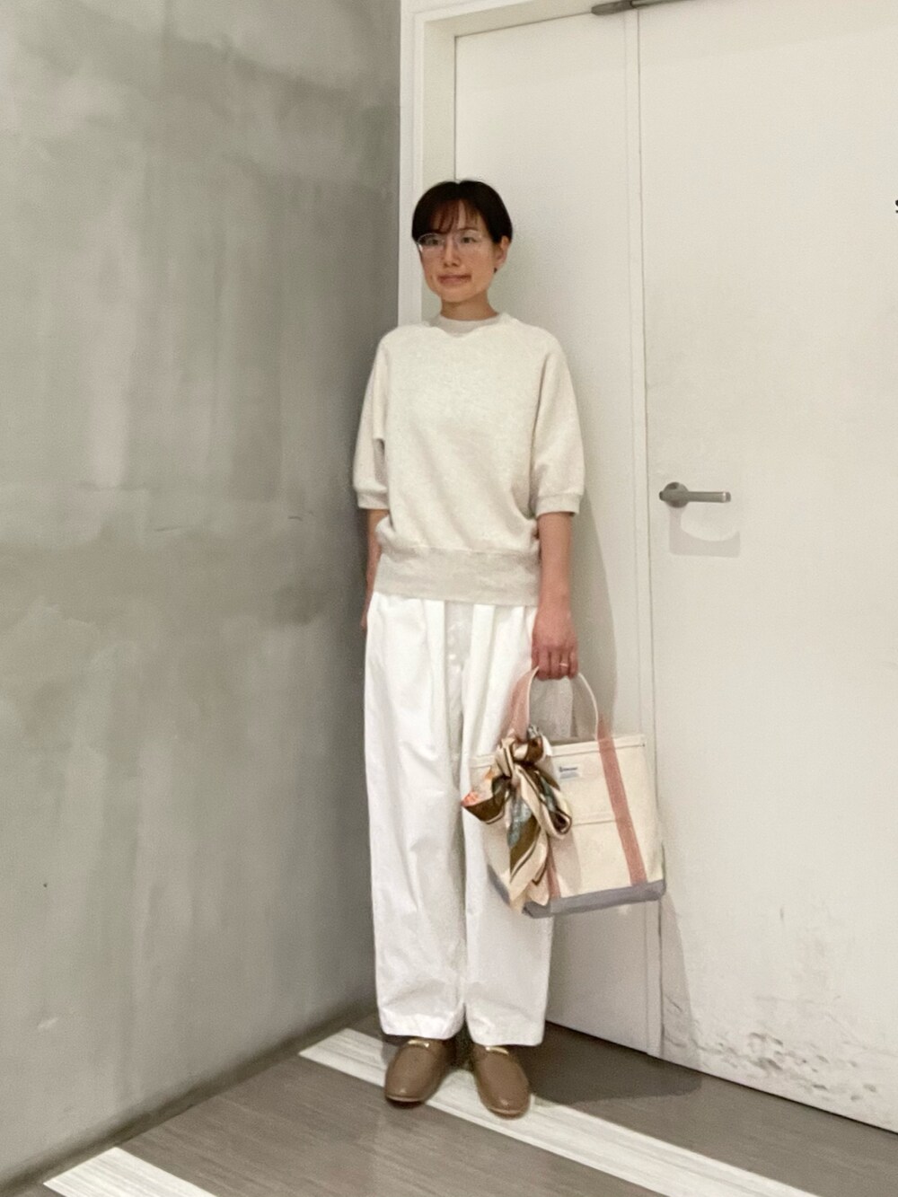 ホワイト系のその他パンツ、ベージュ系のスウェット、ベージュ系のトートバッグを着用したレディースの春コーディネートの2枚目の写真