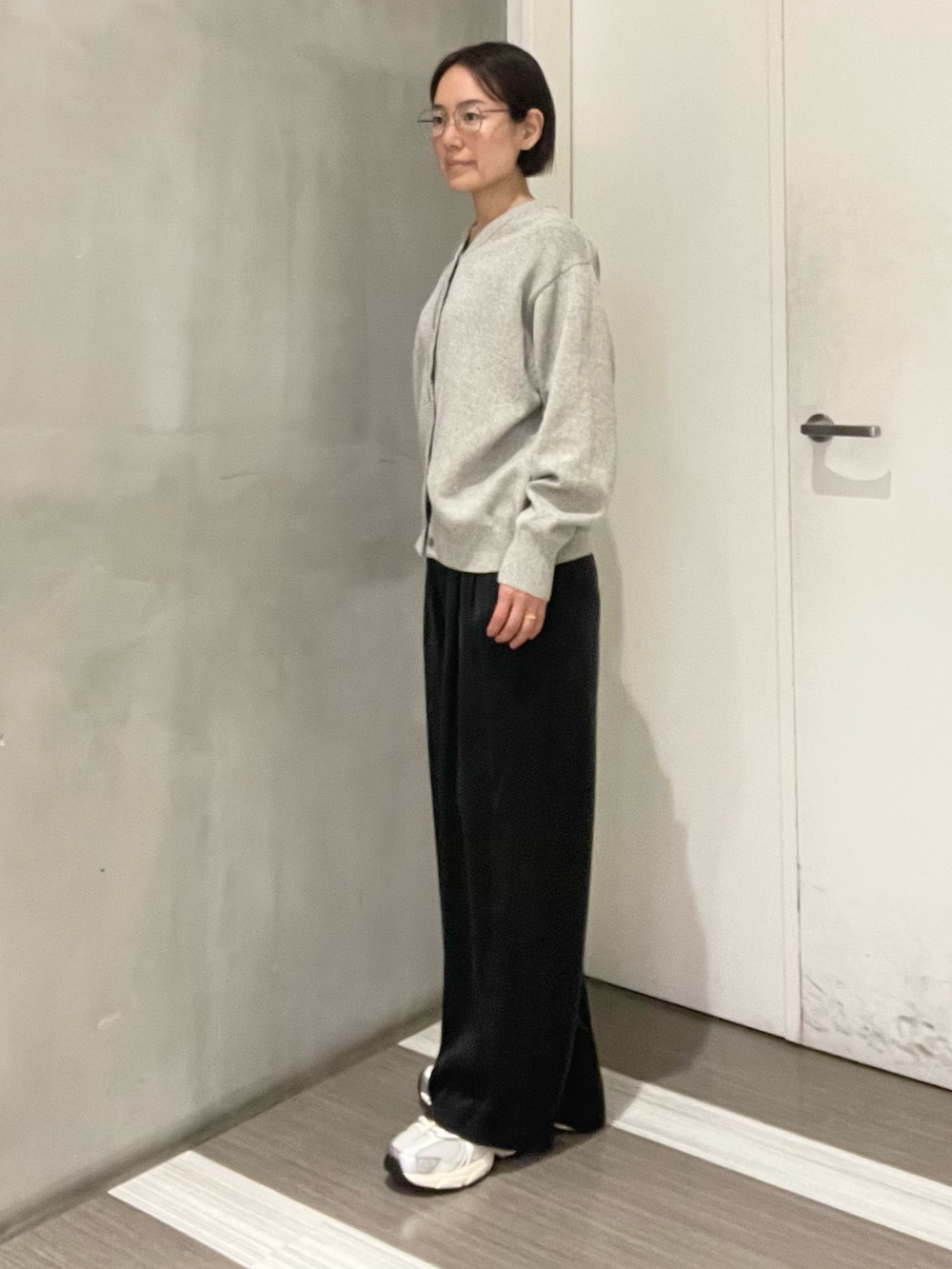 グレー系のニット/セーター、ブラック系のその他パンツ、シルバー系のスニーカーを着用したレディースの冬コーディネートの2枚目の写真