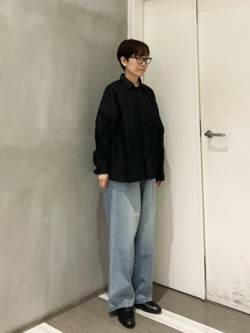 ブラック系のローファー、ホワイト系のTシャツ/カットソー、ブラック系のカバーオールを着用したレディースの春コーディネートの4枚目の写真