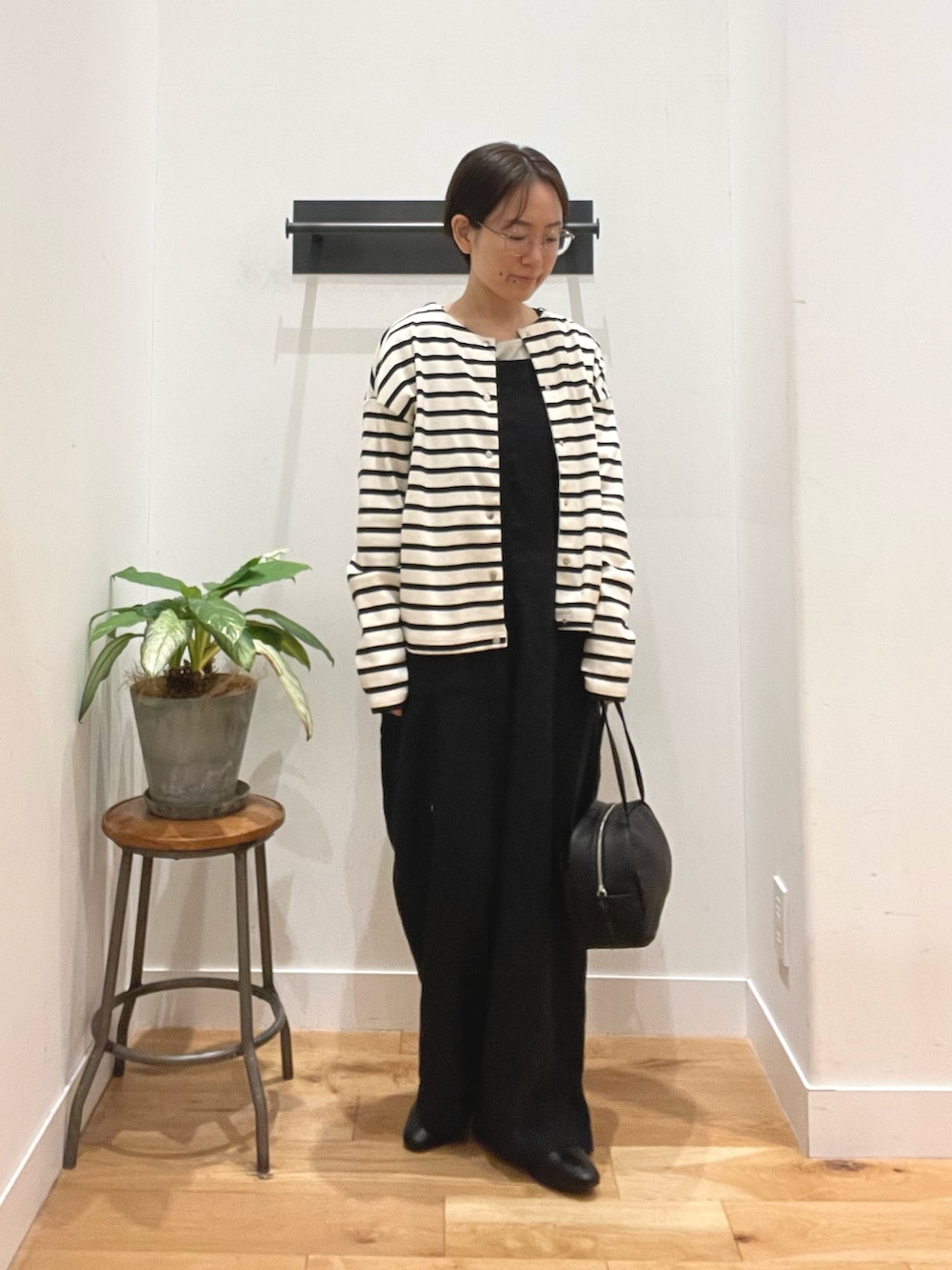ブラック系のボストンバッグ、ブラック系のその他シューズ、その他のカーディガン/ボレロを着用したレディースの春コーディネートの4枚目の写真