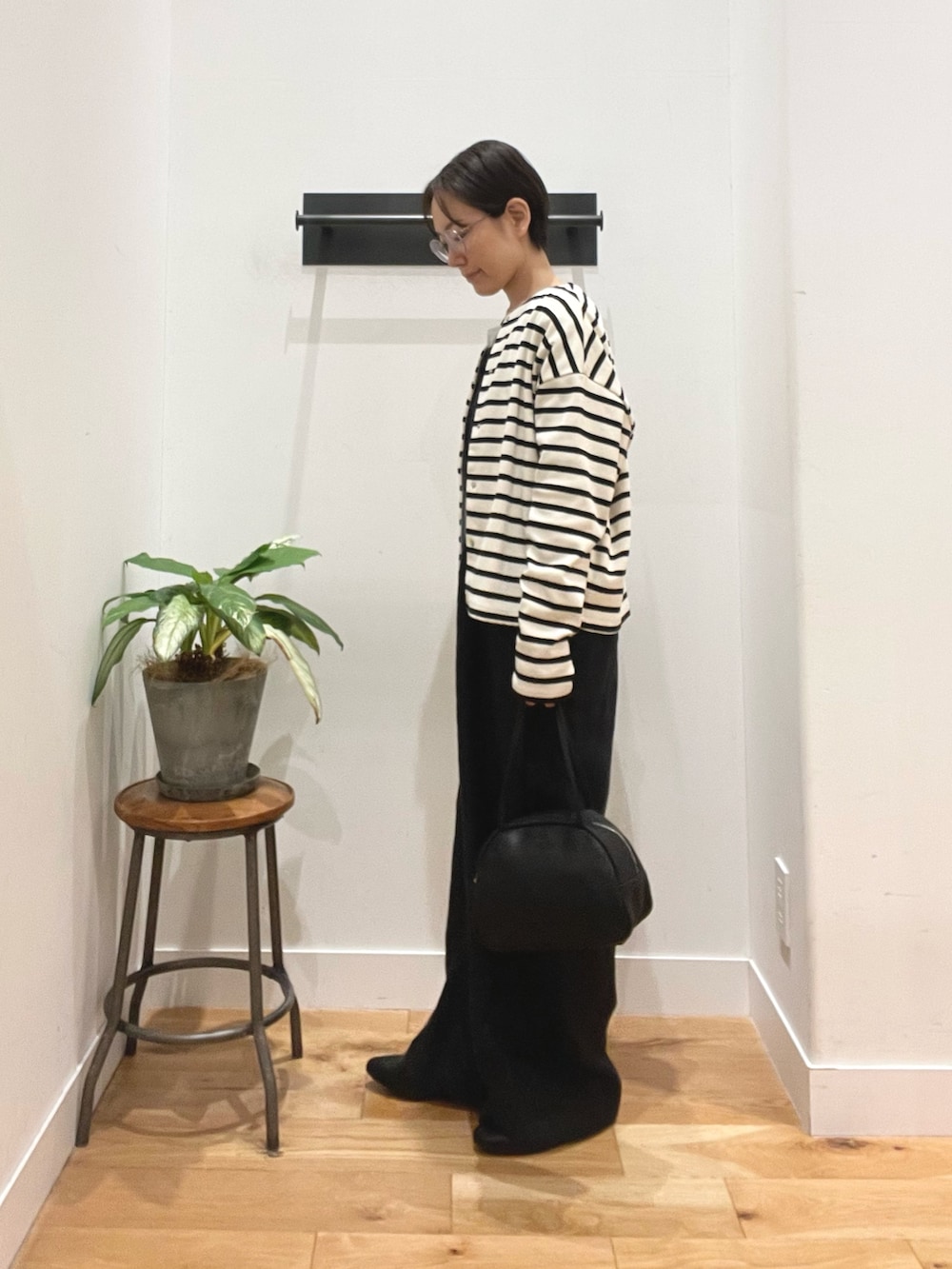 ブラック系のボストンバッグ、ブラック系のその他シューズ、その他のカーディガン/ボレロを着用したレディースの春コーディネートの2枚目の写真