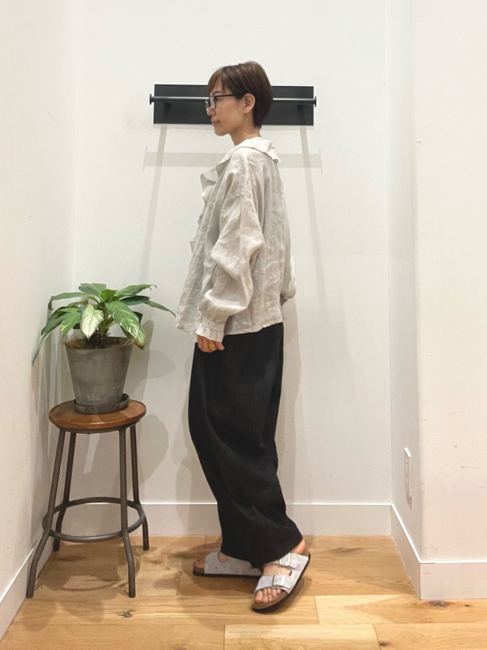 グレー系のシャツ/ブラウス、ブルー系のデニムパンツ、ブルー系のサンダルを着用したレディースの夏コーディネートの3枚目の写真