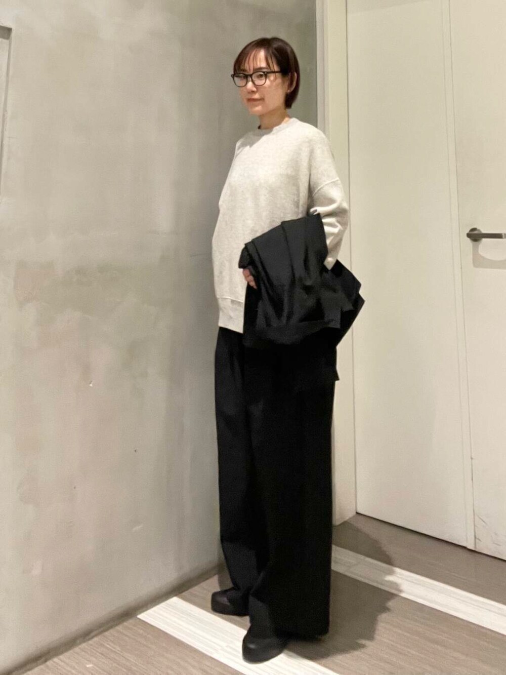 グレー系のスウェット、ブラック系のその他アウター、ブラック系のその他パンツを着用したレディースの春コーディネートの10枚目の写真