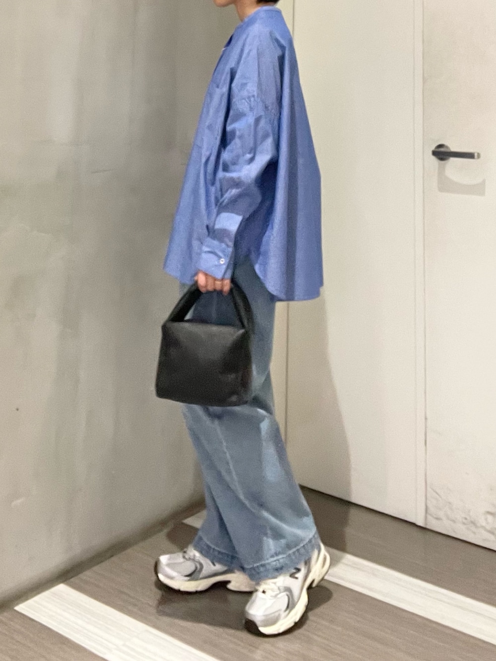 ブルー系のデニムパンツ、ブルー系のシャツ/ブラウス、ブラック系のハンドバッグを着用したレディースの冬コーディネートの2枚目の写真