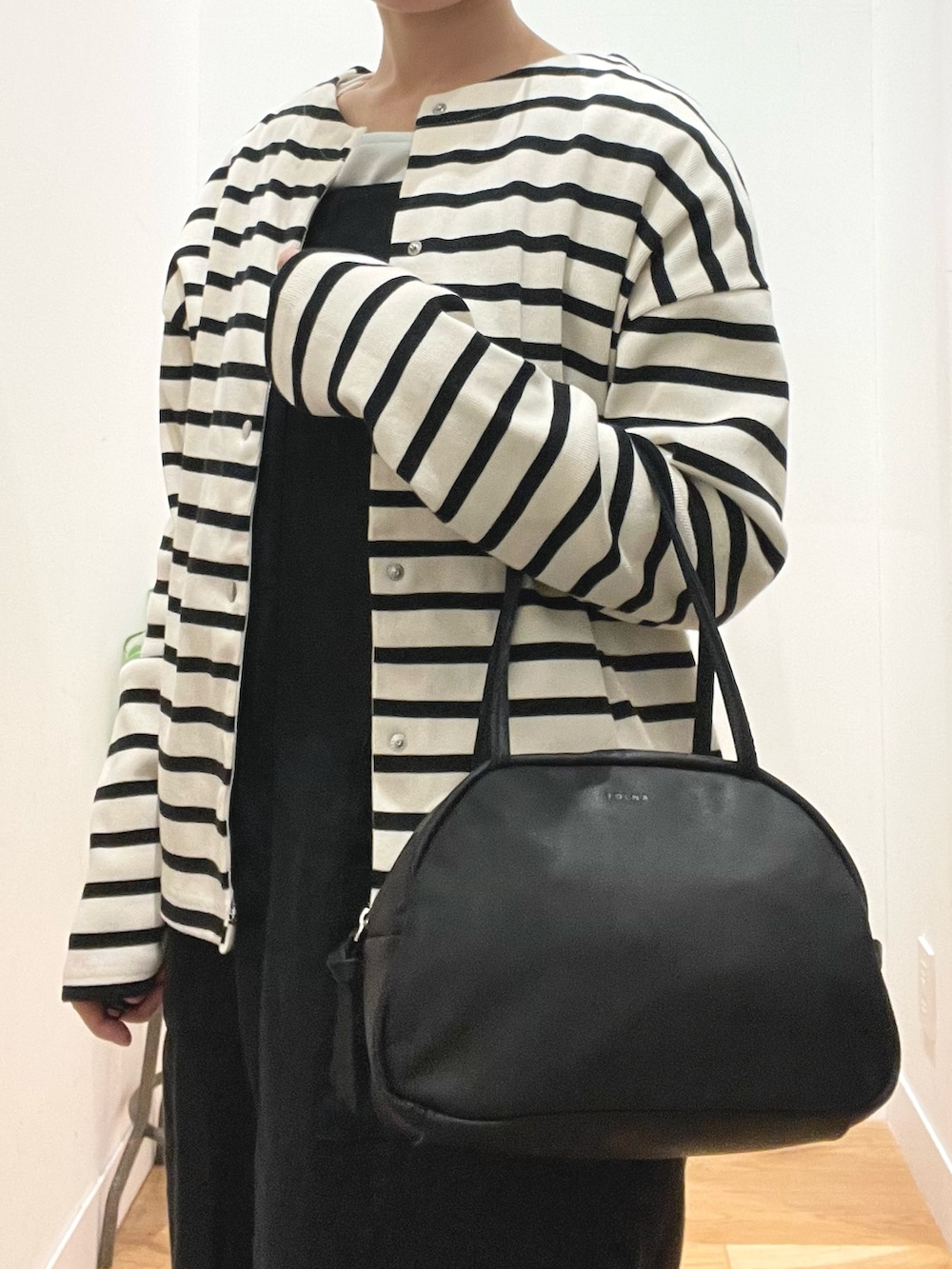 ブラック系のボストンバッグ、ブラック系のその他シューズ、その他のカーディガン/ボレロを着用したレディースの春コーディネートの3枚目の写真