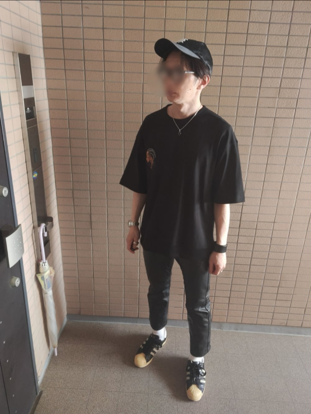 ブラック系のスニーカー、ブラウン系のショルダーバッグ、ブラック系のTシャツ/カットソーを着用したメンズの春コーディネートの2枚目の写真