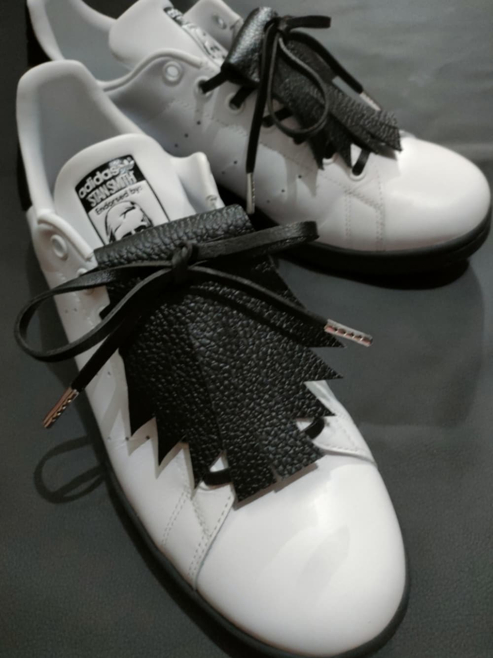 ホワイト系のスニーカー、ブラック系のカーゴパンツを着用したメンズの夏コーディネートの4枚目の写真